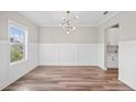 Bright dining room features modern light fixture, wainscoting, and hardwood floors at 442 Payne Rd, Woodstock, GA 30188