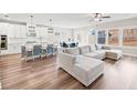 Open-concept living room with hardwood floors, large windows, and a modern ceiling fan at 442 Payne Rd, Woodstock, GA 30188