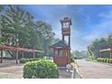 Inviting community entrance with a wooden clock tower and manicured landscaping at 783 Lost Creek Cir, Stone Mountain, GA 30088