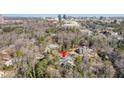 A high angle view showing the house surrounded by trees in a neighborhood and a distant cityscape at 1005 W Kingston Dr, Atlanta, GA 30342