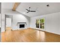 Bright living room with wood-look floors, white brick fireplace and sliding door to balcony at 330 Warm Springs Cir, Roswell, GA 30075