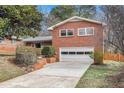 Well-maintained brick home with attached garage, complemented by lush landscaping at 1485 Camelot Ln, Tucker, GA 30084