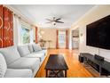 Bright living room with hardwood floors, a ceiling fan, and a comfortable gray sofa at 1485 Camelot Ln, Tucker, GA 30084