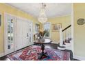 Inviting foyer featuring a decorative chandelier, a round entry table, and traditional staircase at 1241 Briarcliff Rd, Atlanta, GA 30306