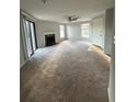 Living room with neutral carpet, ceiling fan, fireplace, and natural light at 1376 Keys Lake Ne Dr, Brookhaven, GA 30319