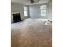 Spacious living room featuring a fireplace, two windows, and a ceiling fan at 1376 Keys Lake Ne Dr, Brookhaven, GA 30319
