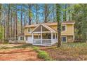 Attractive two-story home with a covered front porch, stone accents, and a serene wooded backdrop at 8640 Embrey Dr, Jonesboro, GA 30236