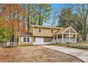 Inviting two-story home with covered porch, stone accents, and mature trees in a peaceful setting at 8640 Embrey Dr, Jonesboro, GA 30236