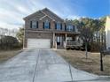 Charming two-story brick home featuring a covered porch, attached two-car garage and beautifully landscaped front yard at 3309 Gardenside Walk, Loganville, GA 30052