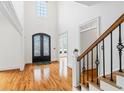 Bright foyer with soaring ceilings, hardwood floors, and elegant ironwork on the staircase and decorative glass front doors at 5170 Deerlake Dr, Alpharetta, GA 30005