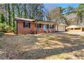 Traditional brick home with an attached garage and covered porch at 1465 Rockbridge Rd, Stone Mountain, GA 30087