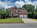 Charming two-story brick home with manicured lawn, a two-car garage and striking red shutters at 3302 Fieldwood Se Dr, Smyrna, GA 30080