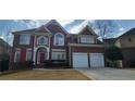 Charming brick home with a two-car garage, red shutters, and beautifully designed architectural details at 3302 Fieldwood Se Dr, Smyrna, GA 30080