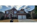 Elegant brick home featuring a two-car garage and well-manicured lawn and classic architectural design at 3302 Fieldwood Se Dr, Smyrna, GA 30080