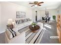 Staged living room with white sofa, striped rug, neutral walls, and a view into dining area at 4227 Pine Cir, Forest Park, GA 30297