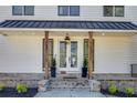 Inviting front porch with wood columns, elegant lighting, and meticulously maintained landscaping at 1537 Harts Mill Ne Rd, Brookhaven, GA 30319