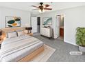 Stylishly staged main bedroom with gray carpet, ceiling fan, walk-in closet and ensuite bathroom at 1100 Cotton Gin Dr, Woodstock, GA 30188