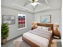 Cozy staged bedroom with tray ceiling, neutral decor, and soft lighting for a relaxing ambiance at 213 Ermines Way, Mcdonough, GA 30253