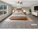 This staged main bedroom features a neutral color palette, a large window, and a ceiling fan at 2740 Peachtree Parc Ln, Lawrenceville, GA 30043