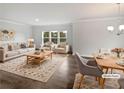 Bright, staged living room with elegant furniture, hardwood floors, large windows and modern decor at 2976 Rambler Dr, Loganville, GA 30052