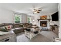 Cozy living room features a stone fireplace, plush leather seating, and natural light at 605 Jeffrey Ct, Woodstock, GA 30188