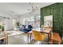 Open-concept living area with blue sofa, dining set, stylish lighting, and leafy green wall for a unique modern design at 680 Greenwood Ne Ave # 202, Atlanta, GA 30306