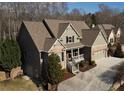 Attractive brick home with a covered porch, attached garage, and well-maintained landscaping, in a wooded suburban setting at 2131 Independence Ln, Buford, GA 30519