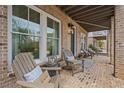 Relaxing front porch with brick flooring and comfortable seating, perfect for enjoying the outdoors at 1004 Baldwin Dr, Milton, GA 30009