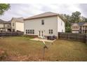 Back exterior of the home with a small, private concrete patio and fenced backyard at 430 St Annes Pl, Covington, GA 30016