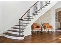 Elegant staircase with dark wood treads and decorative iron railing, accented by floral wallpaper at 1355 Cashiers Way, Roswell, GA 30075