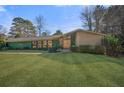 Charming front exterior featuring a lush lawn and mature trees framing a single-story home at 2584 Regency W Dr, Tucker, GA 30084