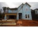 New home under construction featuring exposed framing, blue vapor barrier, and a two-car garage at 4435 Beechnut Cir, Cumming, GA 30028