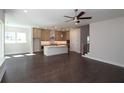 Open-concept kitchen featuring a center island, modern pendant lighting and dark hardwood floors at 4435 Beechnut Cir, Cumming, GA 30028