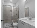 Modern bathroom features a tiled shower with a glass door, vanity with a sink, and neutral color scheme at 4830 Briscoe Dr, Cumming, GA 30028