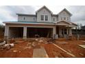Under-construction two-story home featuring a three-car garage with stone accents and a covered porch at 4830 Briscoe Dr, Cumming, GA 30028