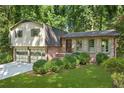Charming home with a two-car garage, brick and siding accents, and landscaped front yard at 4883 Rock Haven Dr, Lilburn, GA 30047