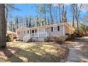 Well-maintained home featuring a front porch, brick facade, and driveway surrounded by mature trees at 1945 Dodson Sw Dr, Atlanta, GA 30311
