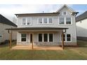 A rear exterior highlights a covered patio, stone accents, and a lush green lawn at 4780 Briscoe Dr, Cumming, GA 30028