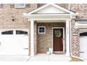 Inviting front porch of a townhome, featuring a decorative wreath on the door and well-maintained landscaping at 222 Ellis Ln, Woodstock, GA 30189