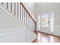 Bright foyer featuring hardwood floors, staircase with metal railing, and front door at 648 Ocean Ave, Canton, GA 30114