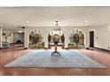 Grand foyer with arched openings, wrought iron details, a large area rug, and views to a fireplace in the distance at 130 Woodlawn Ne Dr, Marietta, GA 30067
