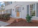 Inviting home entrance featuring a wooden door with glass and well-kept landscaping at 1040 Millridge Se Ln, Marietta, GA 30067