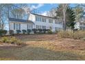 Traditional home with white exterior, showcasing lawn and manicured shrubbery at 1040 Millridge Se Ln, Marietta, GA 30067