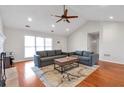Open living space with vaulted ceilings, hardwood floors, and a cozy gray sectional sofa at 2685 Archer Way, Dacula, GA 30019