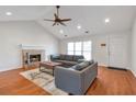 Bright living room featuring hardwood floors, a fireplace, and a comfortable gray sofa set at 2685 Archer Way, Dacula, GA 30019