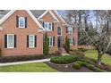 Beautiful brick home with lush landscaping, mature trees, and a well-manicured front lawn at 832 Forest Path Ln, Alpharetta, GA 30022