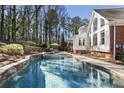 Inviting backyard pool with spa, waterfall feature, and ample seating for outdoor relaxation at 832 Forest Path Ln, Alpharetta, GA 30022