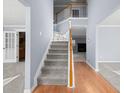 Light-filled foyer boasts hardwood floors, a staircase with white railings and neutral paint at 2010 Skylar Leigh Dr, Buford, GA 30518