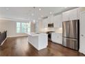 Modern kitchen with white cabinets, stainless steel appliances, island with sink, and pendant lights at 3533 Koyla Lndg # 5, Chamblee, GA 30341