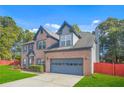 Beautiful two-story brick home with blue shutters, attached garage, and mature landscaping at 1021 Adah Ln, Lawrenceville, GA 30043